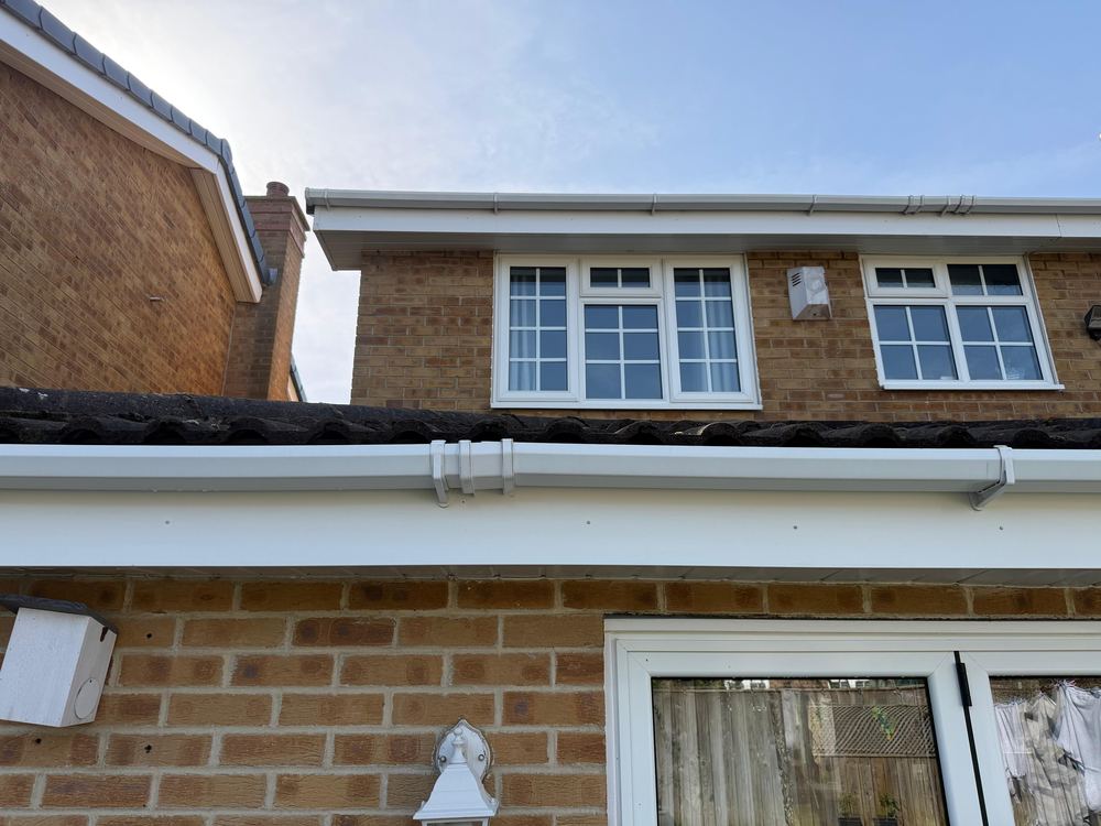 Clean white fascia, soffit and gutter run on the same property after cleaning.