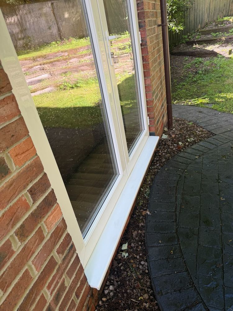 The same window and sill after a pure water clean, with clear glass and a white frame.