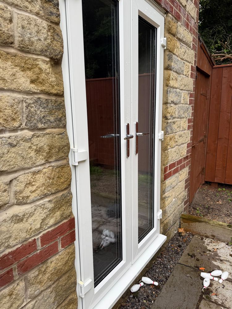 The same French doors after cleaning, with clear glass and a clean frame.