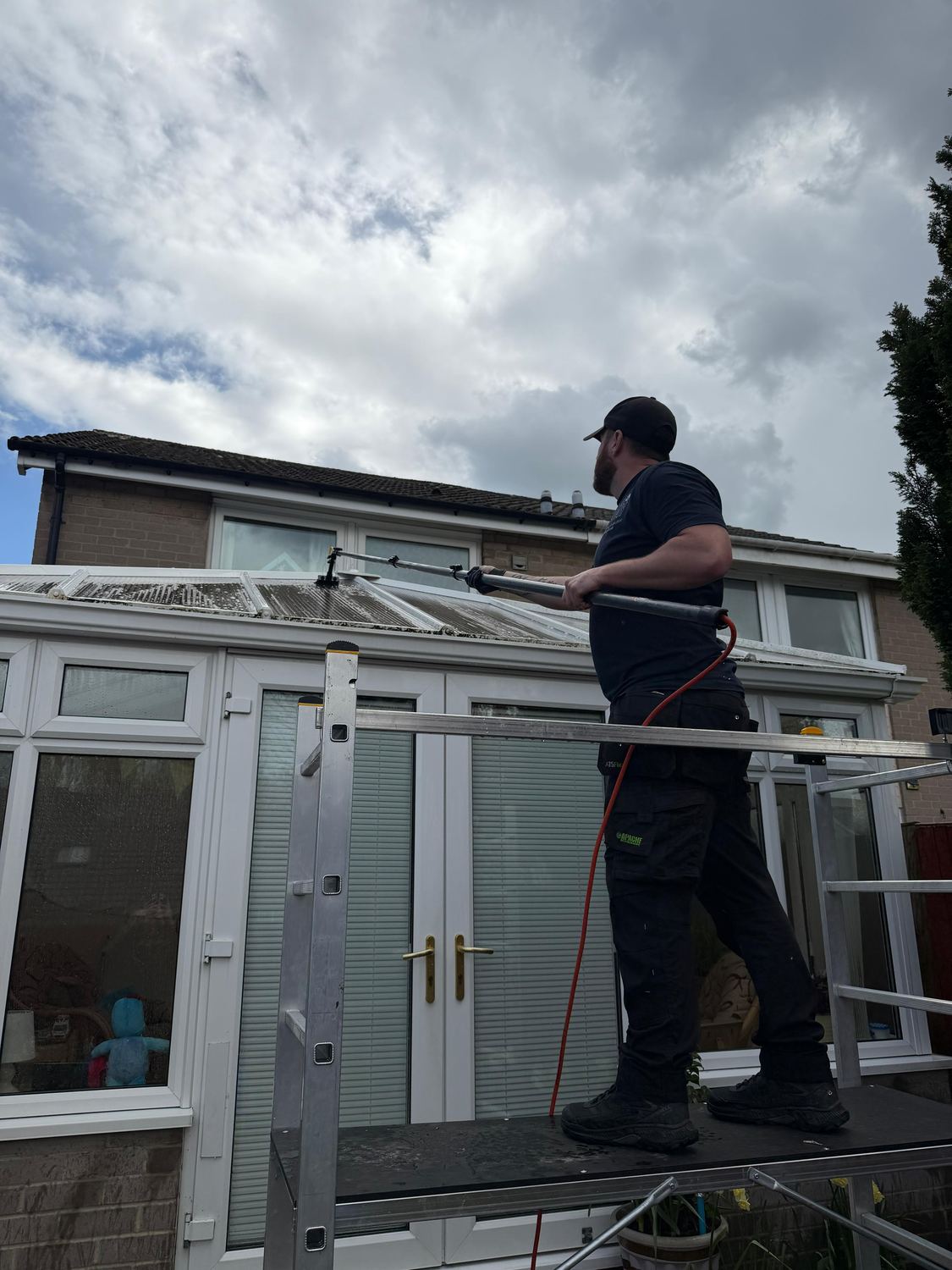A conservatory roof being cleaned from a work platform.