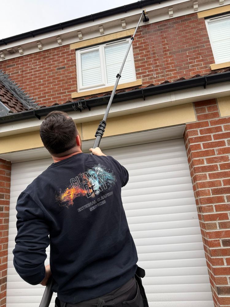 Liam working a fascia from the driveway with an extending pole.